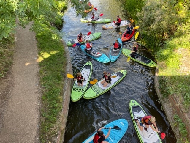 Young people on paddleboards in canal